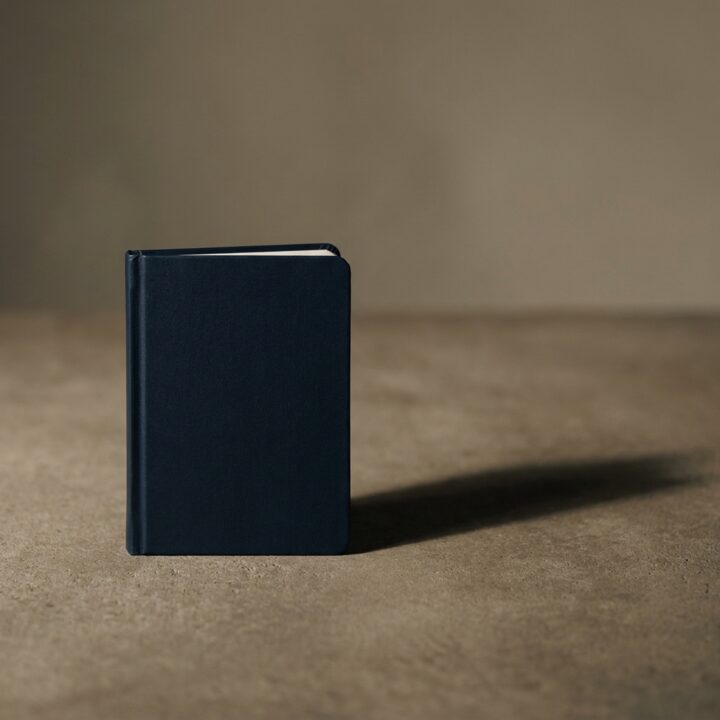 Field Notes No. 04, a navy pocket notebook standing on a concrete surface.
